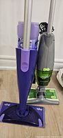 Swiffer WetJet mop and Swiffer Sweep + Vac stick vacuum with cleaning pad packages on floor