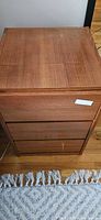 Front view of teak nightstand showing three drawers