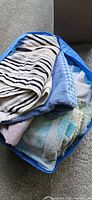 Blue bag filled with assorted striped, blue, gingham and floral towels