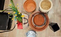 Top view of assorted planters, stands, tray, metal bucket and faux flowers