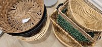 Two stacks of assorted wicker baskets showing variety of shapes, colours and textures
