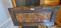 Top view of carved wood panel on chest lid