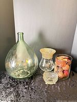All four glass items grouped: demijohn, clear vase with gold rim, cut glass dish, cylinder vase with potpourri