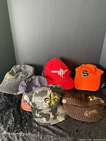 Group shot showing all eleven caps in assorted colors and styles