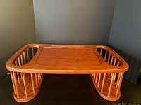 Front view of wooden bed tray showing tilt top and magazine rack sides