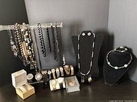 Full lot view showing necklaces on stand, watches, boxed items