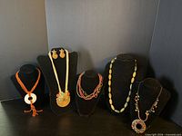 Group shot of all five necklaces and earrings on busts