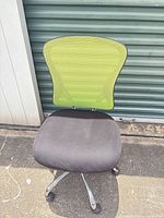 Front view showing green mesh back, black seat, chrome base with casters