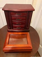 Cherry wood jewelry cabinet with separate glass-lid music box in front
