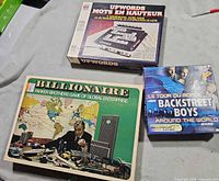 Three board game boxes laid out: Upwords, Billionaire, Backstreet Boys