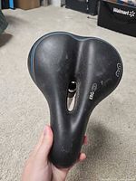 Top view of black bicycle saddle showing ergonomic center cutout and overall wear
