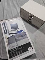 Boxed laptop table beside three-drawer organizer