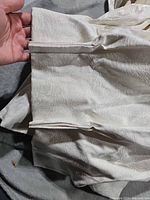 Close-up of pleated header with hooks on ivory fabric