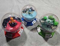 Overview of all three Pokémon dome figures showing colored bases and clear domes