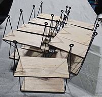 Group of nine hanging shelves showing wood tops and black metal frames