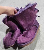 Full view of both purple suede UGG ankle boots