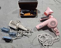 Overview of all items: Kenmore dryer with blue attachments, Merit pink dryer with nozzle, Philips shaver in case