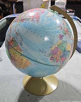 Front view of Replogle globe showing Atlantic Ocean and gold base