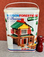 Front of original Jeujura Maison Forestière plastic pail with graphic showing completed house