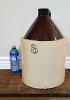Full view of the jug beside a water bottle for scale