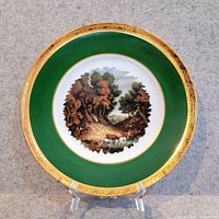 Full view of decorative plate showing green band, gold rim, pastoral center