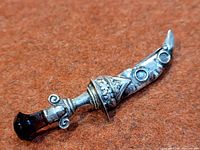 Full view of sterling dagger brooch showing blade and pommel