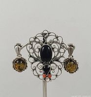 Brooch and both earrings displayed on stand