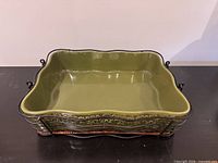 Full view of green ceramic serving dish in metal rack
