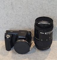 Olympus camera and Nikon lens side by side