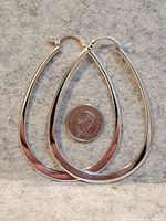 Both sterling silver teardrop hoop earrings beside a U.S. quarter for scale