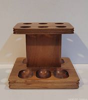 Front view of walnut pipe rack showing six lower wells and overall form