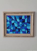 Full view of framed abstract painting hung on wall