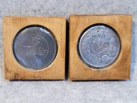 Front view of both coins in wood frames showing Chinese character side and wreath design side