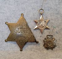 Front view of three medals showing overall designs and relative sizes