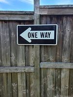 Front view of One Way sign on fence