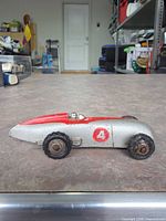 left side view showing silver body, red top, number 4 decal, wheel wear