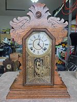 Full front view of oak mantel clock with carved crest and glass door