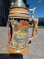 Profile view showing handle, chalet relief, pewter lid