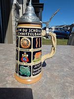 Front view showing German pictorial panels and pewter lid