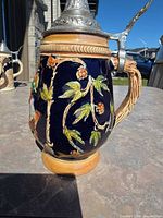 Left profile showing hops vine relief and handle with pewter lid