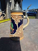 Right profile showing floral relief, handle, pewter lid