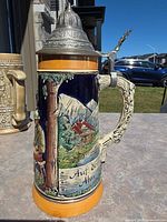 Left profile showing alpine chalet scene and twisted handle