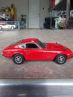 Full left side view of red Kyosho 240Z model car