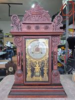 Front view of carved wooden New Haven mantel clock with glass door