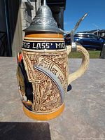 Left profile showing relief leaf motif, text band and pewter lid