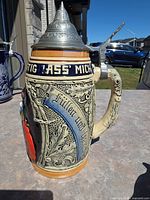 Left profile showing relief foliage and script, pewter lid detail