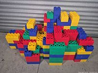 Stack of multicolour oversized plastic blocks against metal backdrop