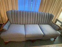 Front view of the three-seat sofa showing upholstery, channel-back, wood arms and legs