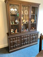 Front view of china cabinet showing full structure with upper glass doors and lower paneled doors