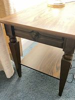 Side view of table showing drawer, legs and lower shelf